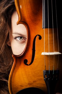 Woman with violin in dark room